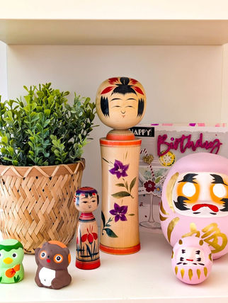 étagère dans une chambre d'enfant avec daruma, kokeshi et petit yokai