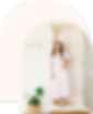 A woman in a white dress standing in front of a door