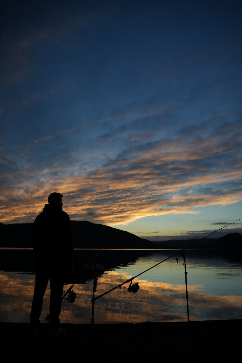 Une silhouette d'homme face à un couché de soleil dantesque.