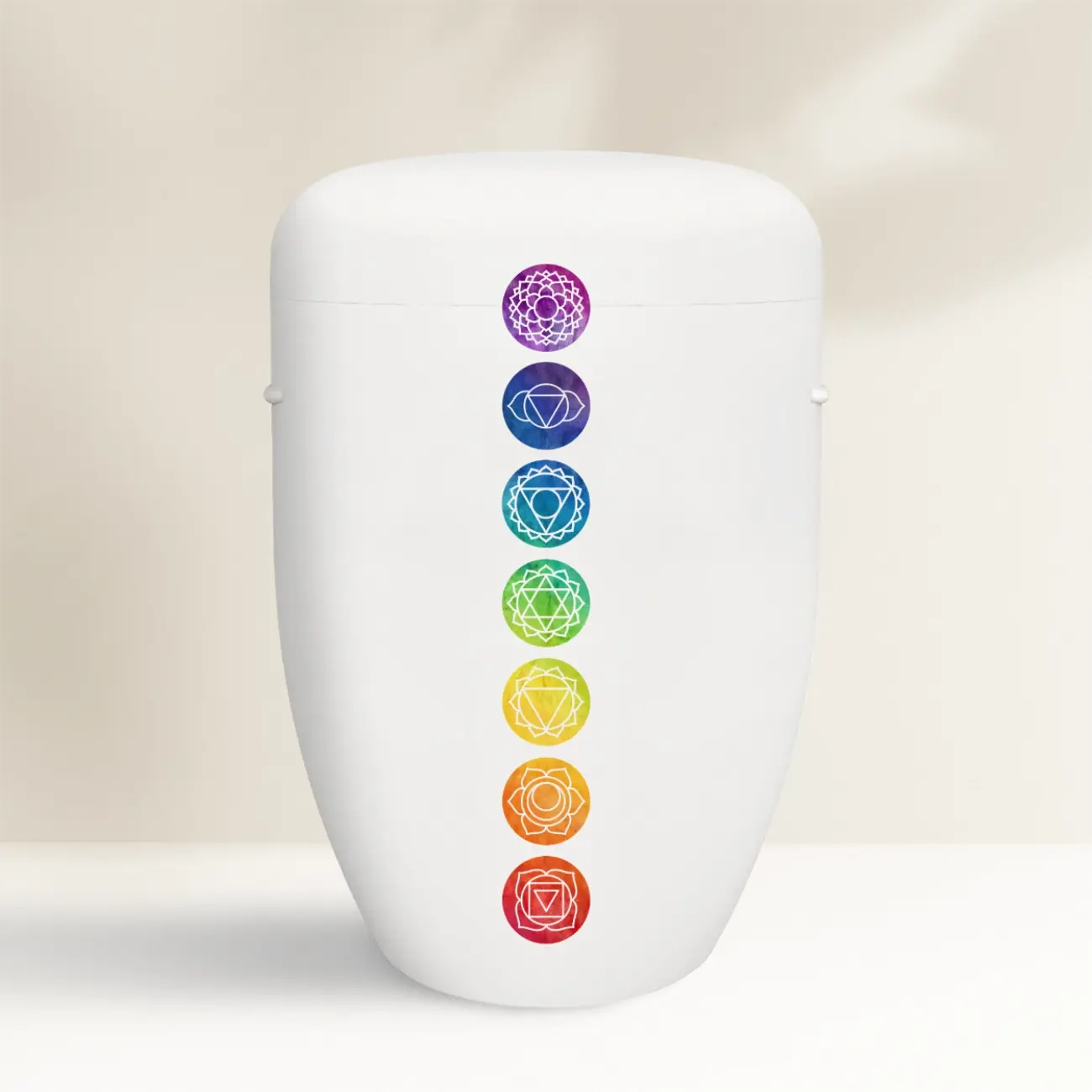 Weiße Urne mit spirituellen bunten Chakren-Symbolen gestaltet
