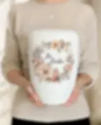 Miniaturbild: Biologisch abbaubare Urne in weiß mit Blumenkranz und Schriftzug "In Liebe" - florales Motiv