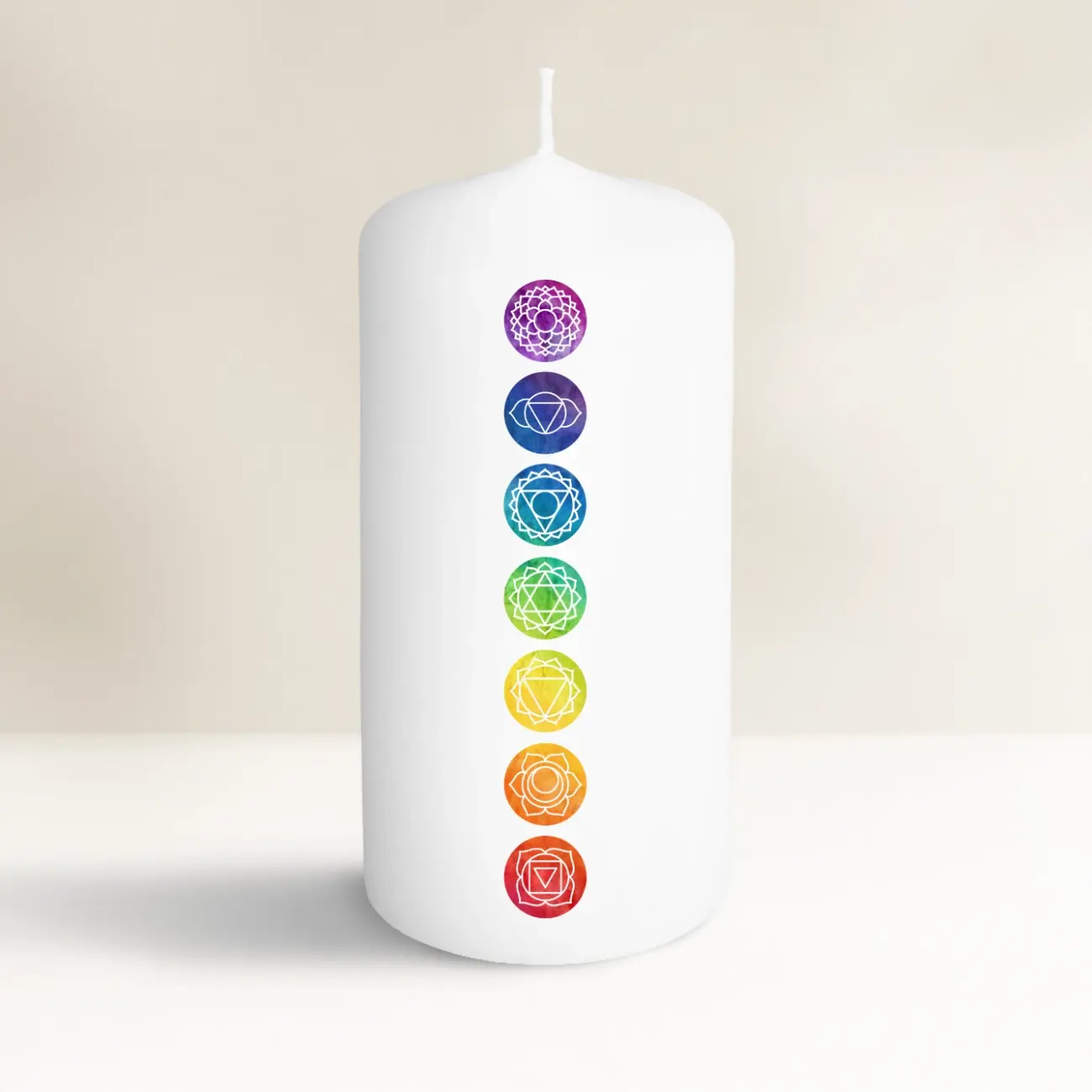 Weiße Kerze mit bunten Chakra-Symbolen, spirituell