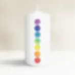 Weiße Kerze mit bunten Chakra-Symbolen, spirituell