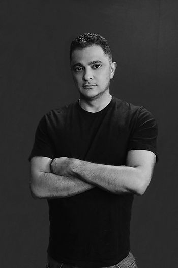 A black and white image of a man with his arms folded