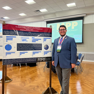 Alejandro next to his poster