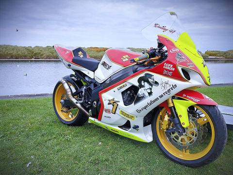 A custom built superbike hearse at a funeral. In the red, black and white theme of the famous motorcyle rider Barry Sheene.