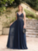 "Woman wearing a sleeveless black pleated maxi dress with fitted bodice and flowing skirt, creating an elegant and romantic