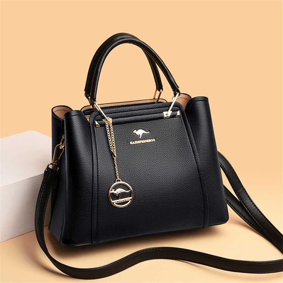 Thumbnail: “Black structured leather handbag with top handles and gold hardware, worn by woman, elegant and sophisticated everyday bag”