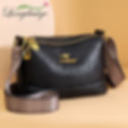 “Black leather shoulder bag with wide patterned strap, elegant modern handbag for everyday use”