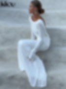 Elegant long-sleeve white maxi dress with a fitted bodice and flowing skirt. Features a soft, minimalist design that creates