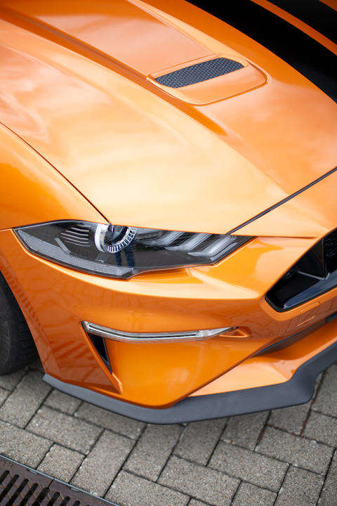 Nahaufnahme der Front und Scheinwerfer eines Ford Mustang mit Carwrapping in 3M Gloss Liquid Copper.