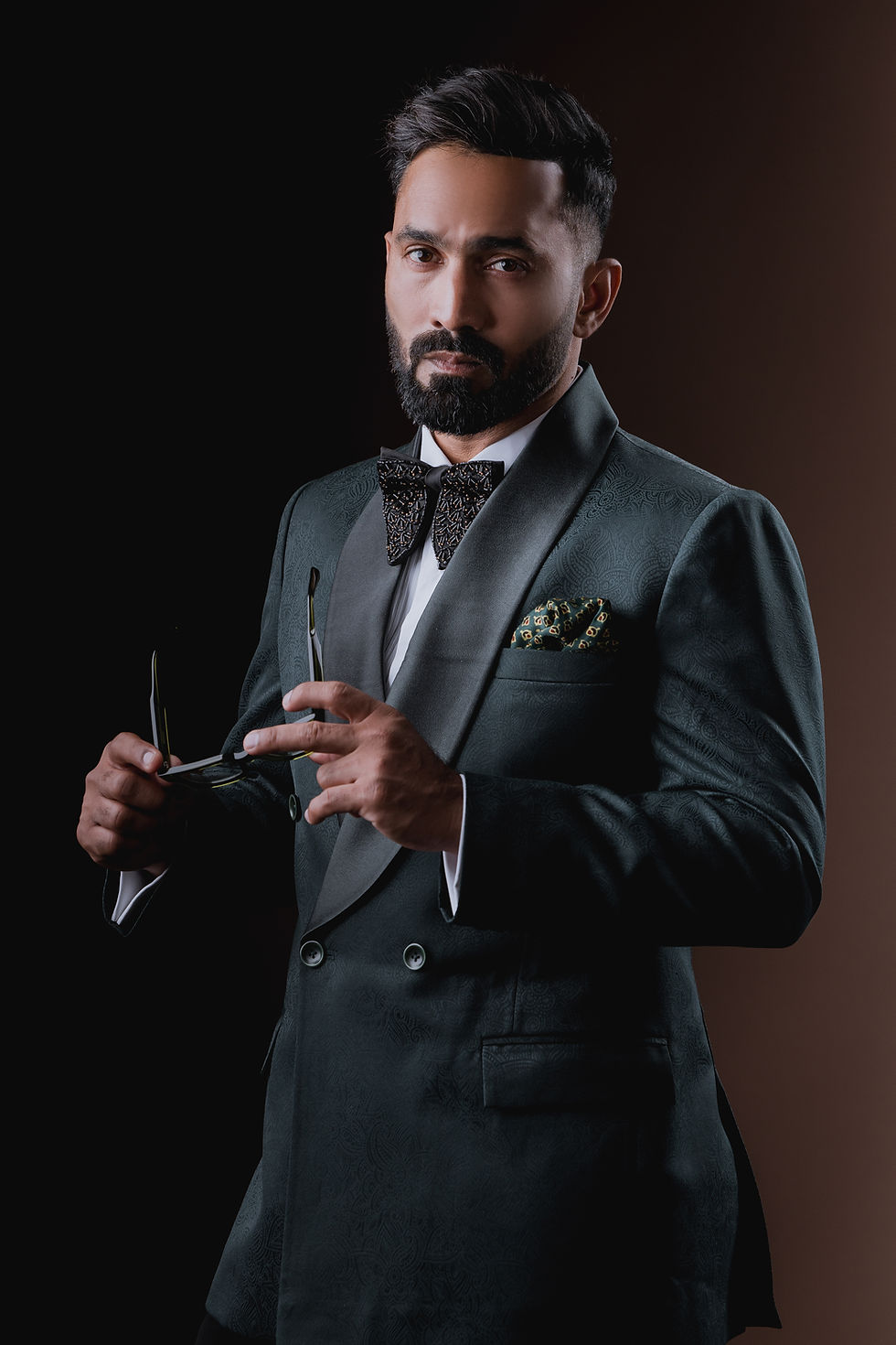 Thumbnail: side view of dinesh karthik standing wearing paisley patterned bottle green dinner suit with black trousers