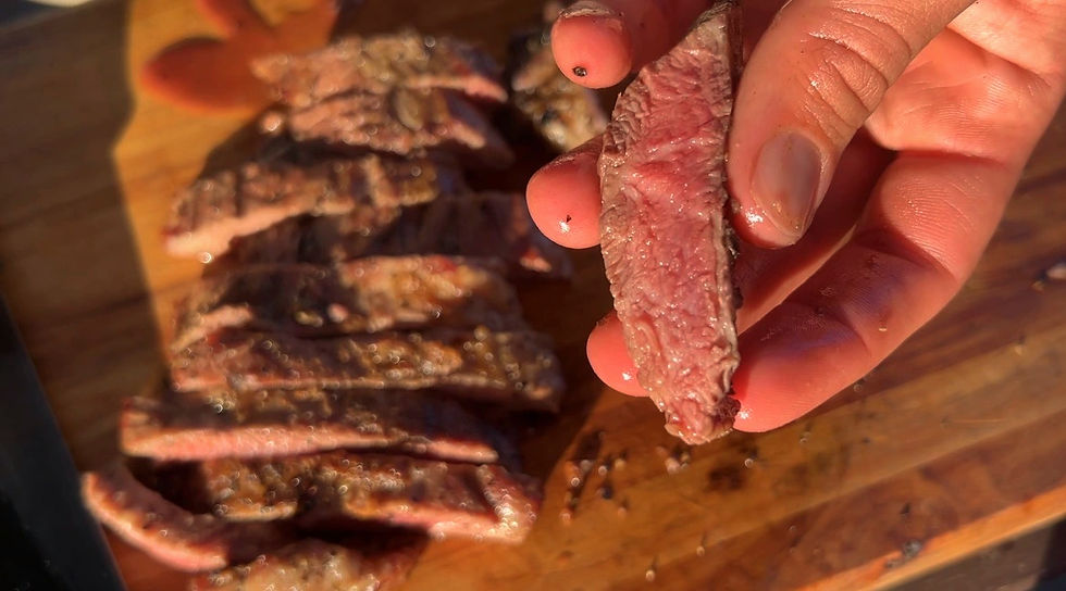 Grilled Iberico Presa on a cutting board, pink inside.