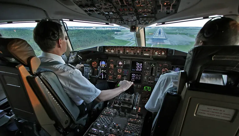 Eye-level view of a commercial airplane cockpit showing flight instruments and controls