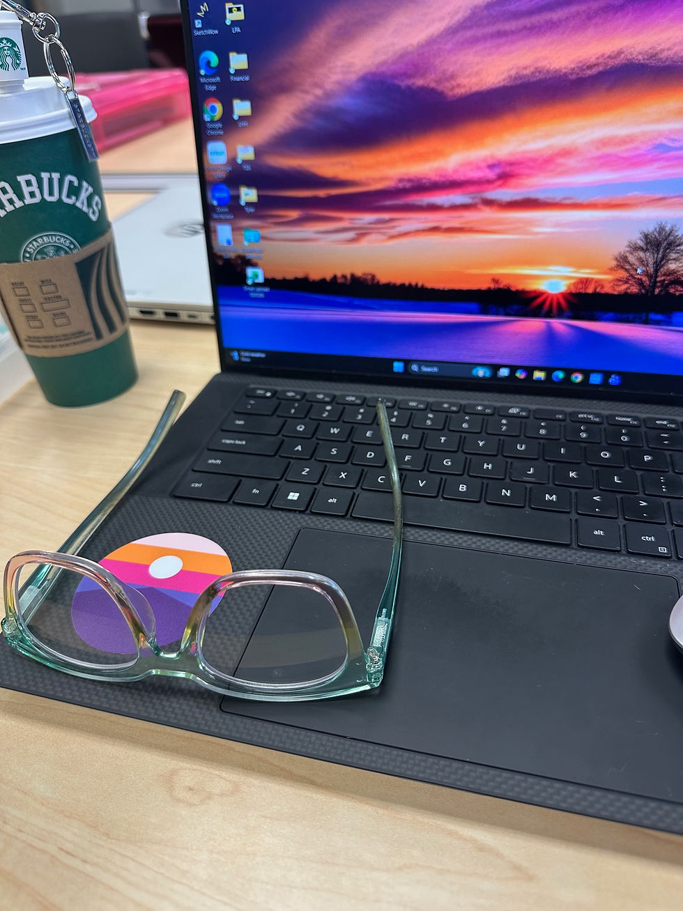 Creating the perfect atmosphere for a productive session: a bright laptop screen, reading glasses, and a hot coffee.