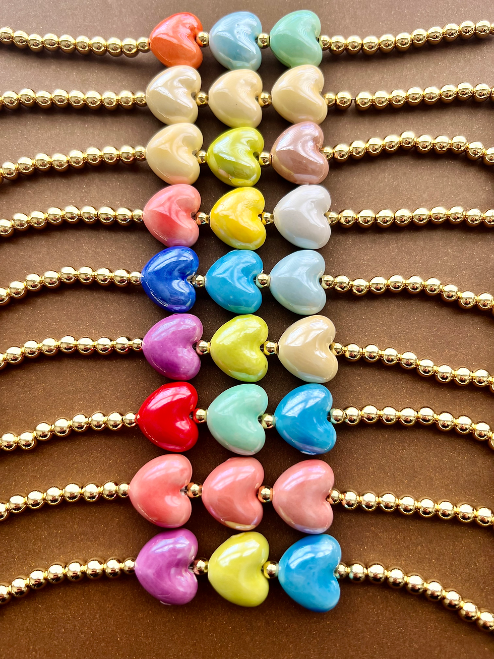 three colorful ceramic heart surrounded by gold beads bracelet