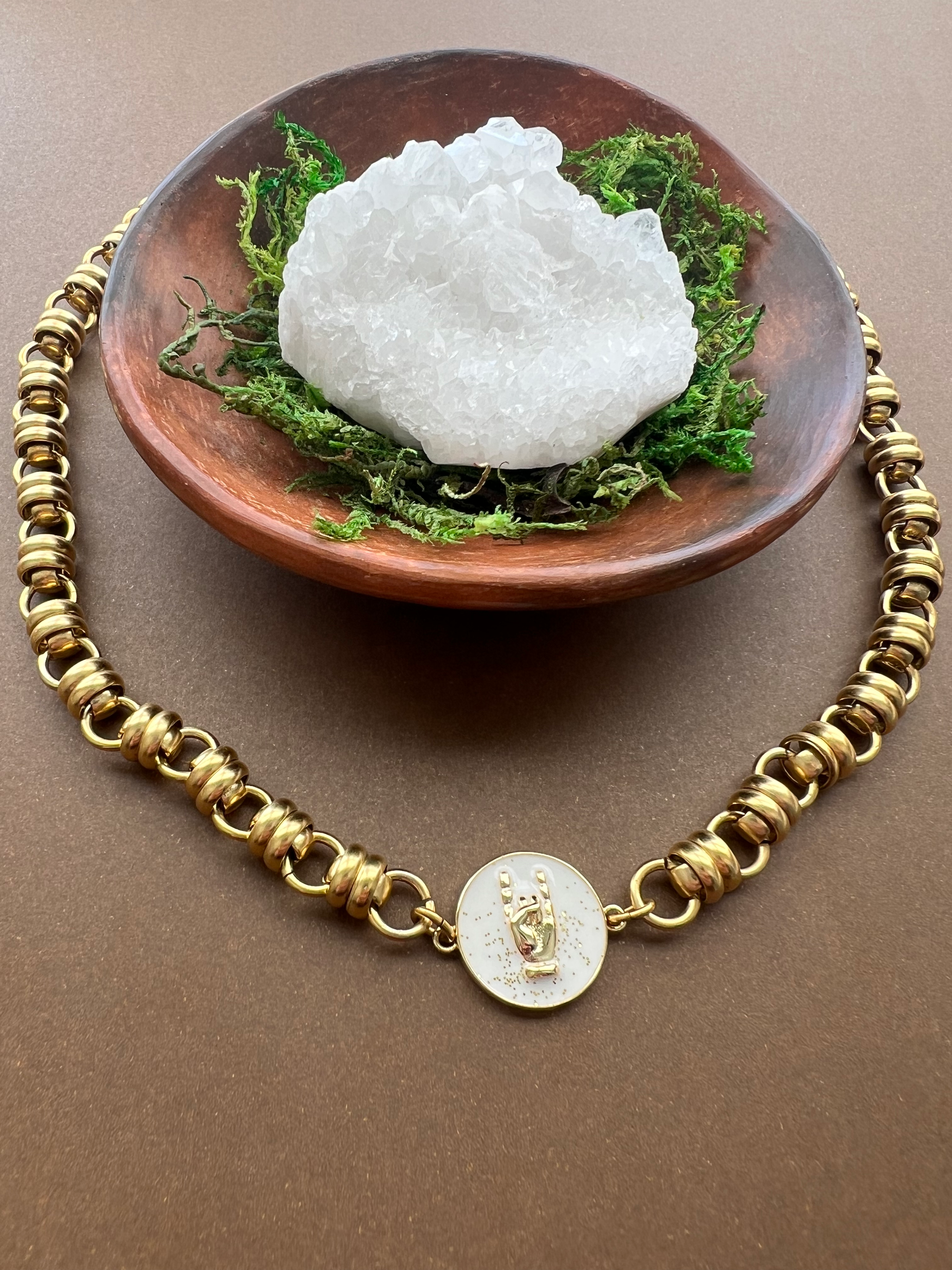 white enamel charm with gold rock on hand symbol on antiqued gold chain