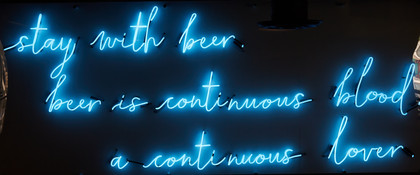 A neon sign quote from Charles Bukowski