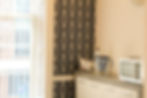 Art deco wallpapered kitchen area with water filter and microwave