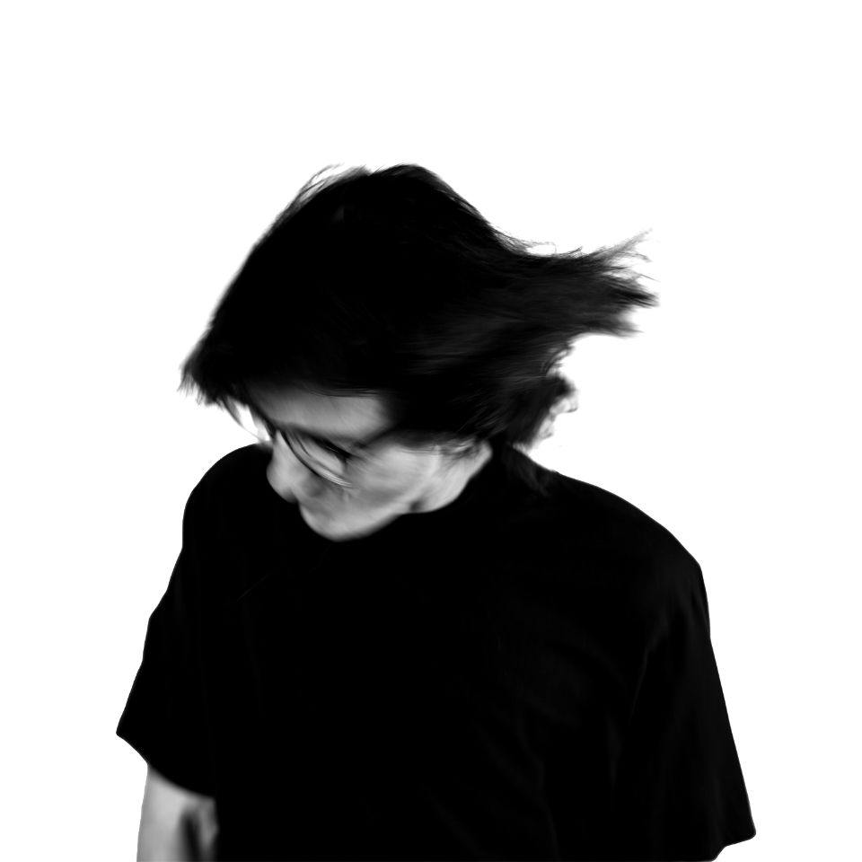 Junge Person mit Brille und wehendem Haar, blickt nach unten. Foto von Stef