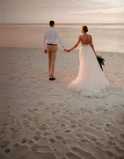 man and woman walking on beach during da