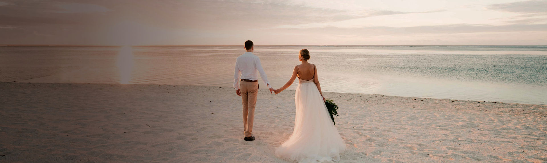 man and woman walking on beach during da