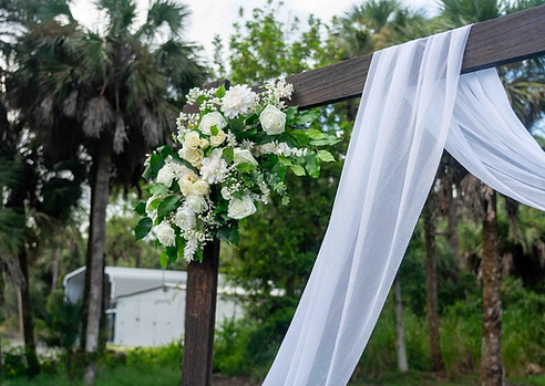 Rustic wedding arch decorated with flowers for a personalized wedding ceremony in Southwest Florida.