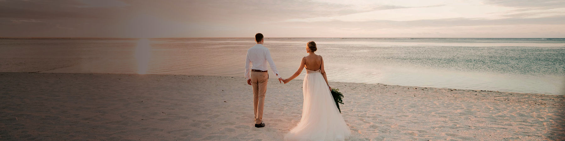 man and woman walking on beach during da