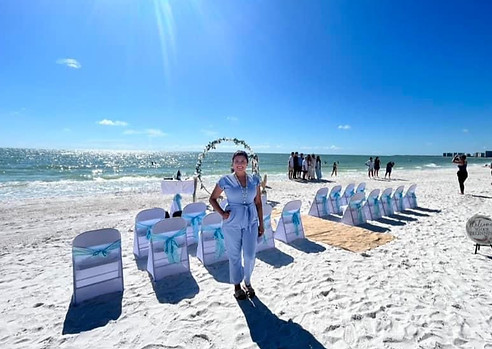 Beach wedding ceremony setup on the Gulf Coast of Florida with white chairs and arch prepared for a romantic seaside wedding.