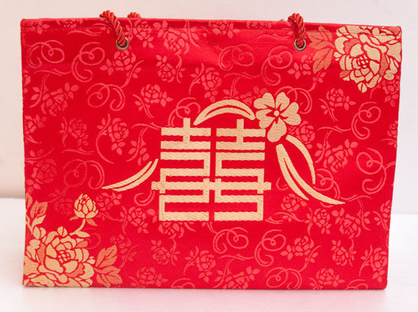 大紅色絲綢手提袋，織繡著牡丹囍字樣