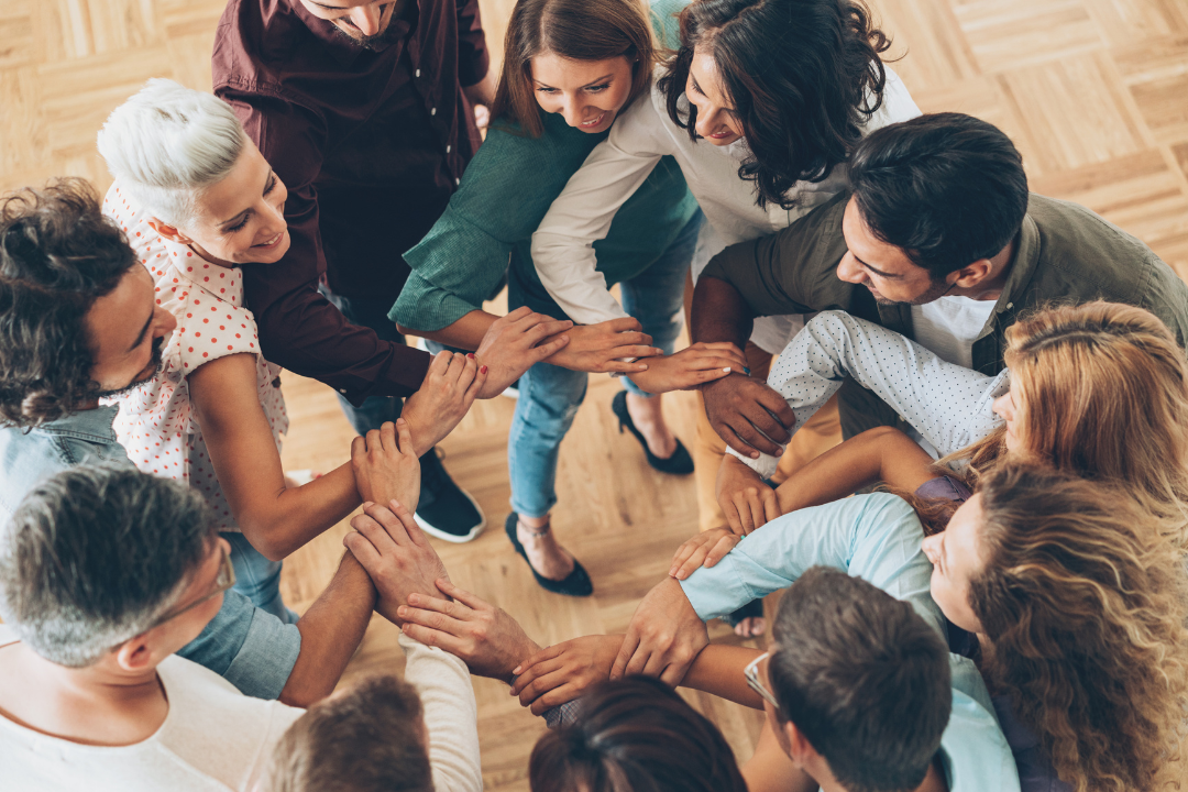 Équipe unie, mains jointes, collaboration autour d'un projet de formation immobilière en ligne