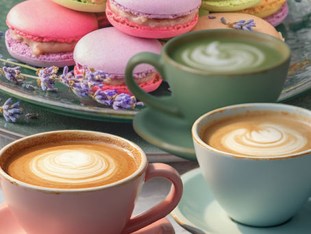 Three colorful cups of coffee with macarons next to it.