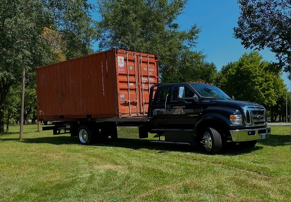 Jimmy Ray's Towing tow truck with 20 foot shipping container loaded on it representing some of the specialty services provided to Spartanburg SC, like container moving and relocation