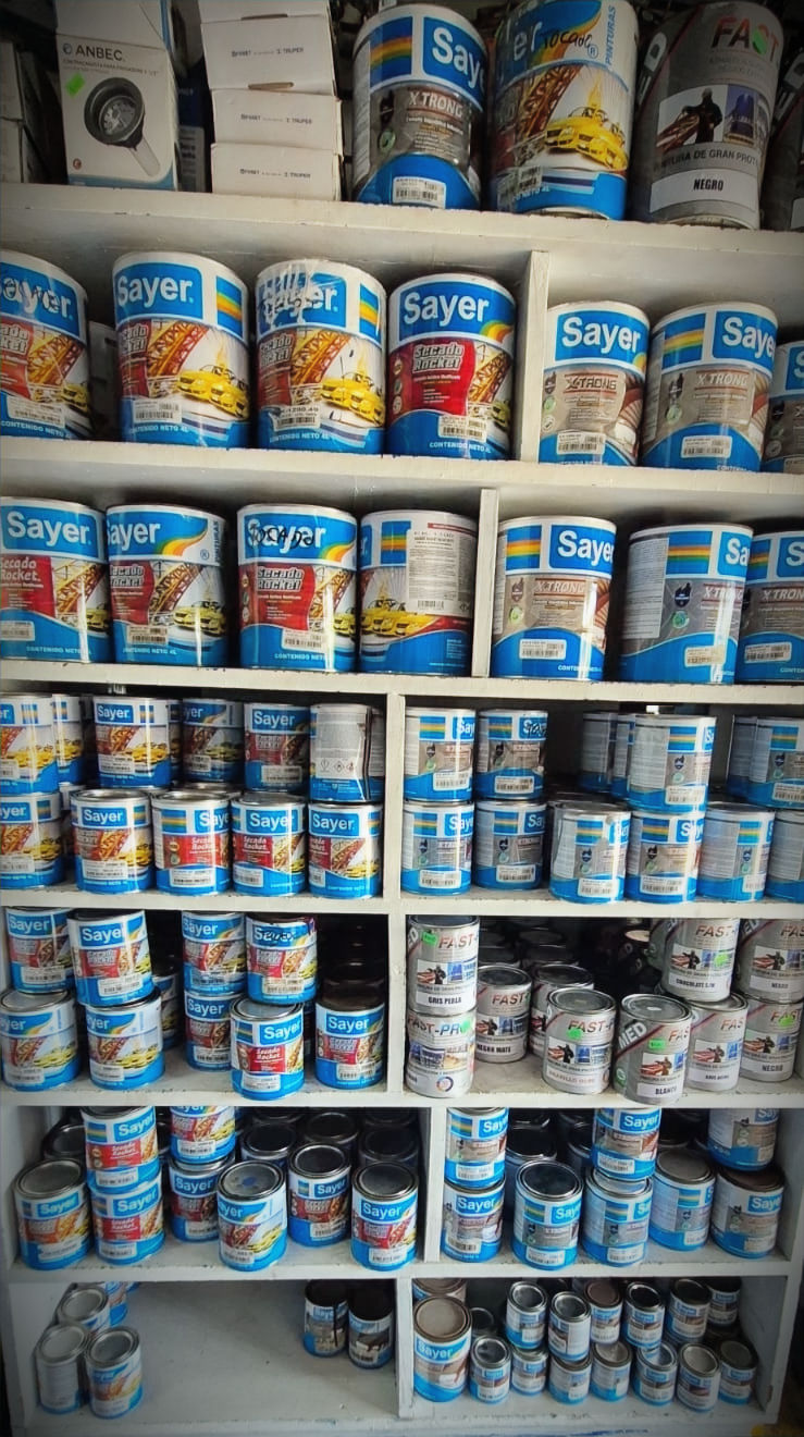 Estante con latas de pintura Sayer y ferretería variada.