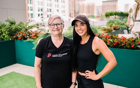 Personal trainer Paris Nahas with her older client, smiling and celebrating after a successful personal training session in downtown Greenville.