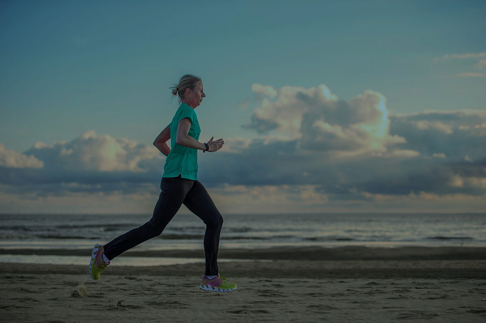 A sober woman running on the beach near our sober living house in Madison, Connecticut