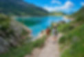 big_Two_friends_during_a_hike_in_the_mountains_walking_near_an_alpine_lake_LAGHI_GEMELLI.j