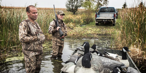 Two hunters with harvested geese