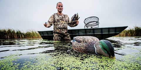 Hunter with ducks in boat
