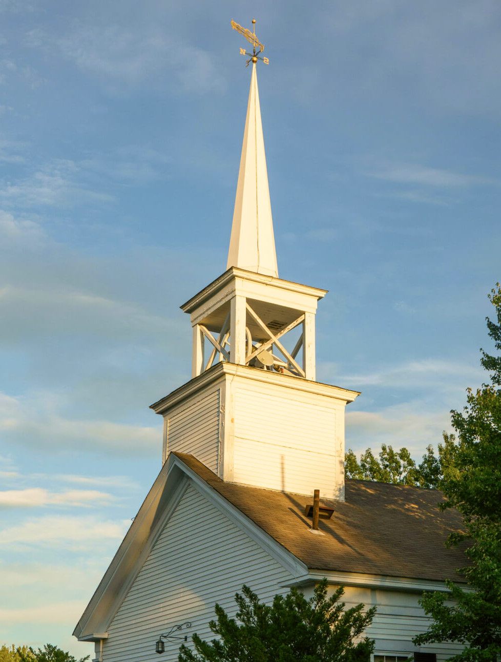 exterior of brick church with a tall steeple