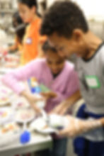 Children putting whip cream on dessert