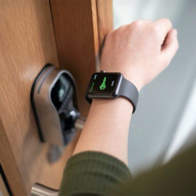 An arm wearing a smart watch touching a sensor to gain entry to a locked room