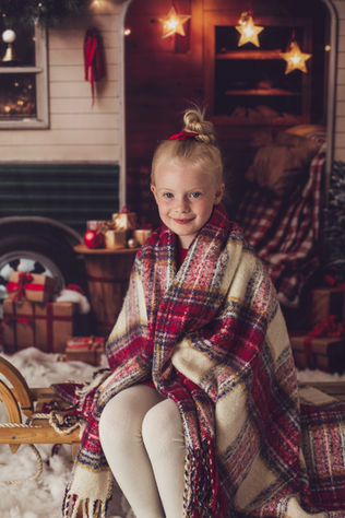 Girls wrapped in a cosy blanket during a Christmas photoshoot in Moonlion Studio, Milton Keynes