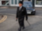 funeral director walking in front of the hearse