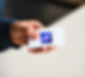 Hand holding card with 'GG' logo, professional business context.