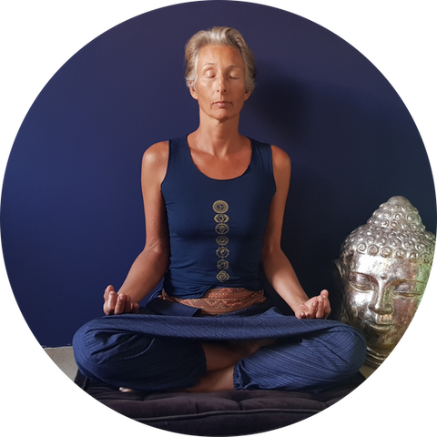 Woman meditating in front of blue wall