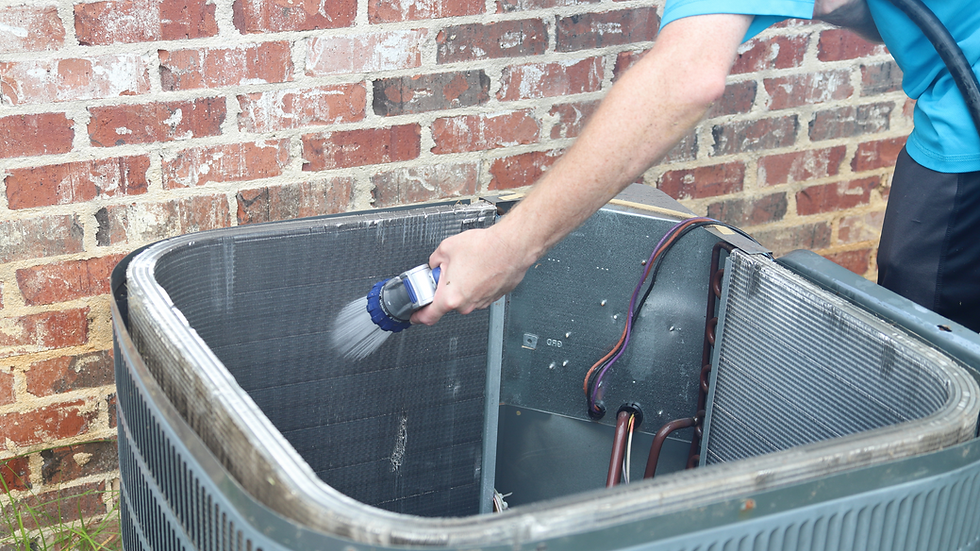 HVAC technician performing seasonal maintenance on an outdoor AC unit in a residential backyard
