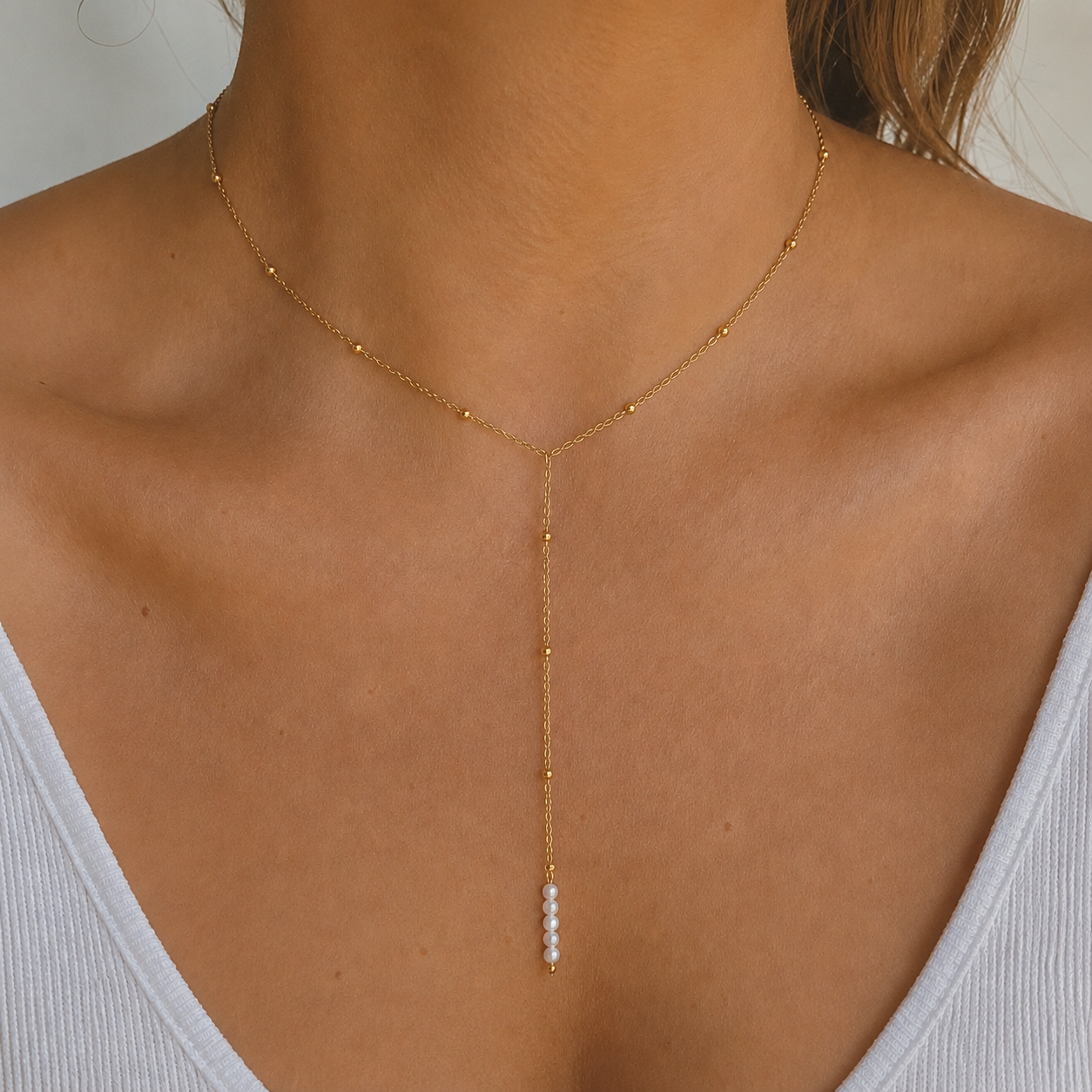 Collier Y doré en acier inoxydable et petites perles de culture porté