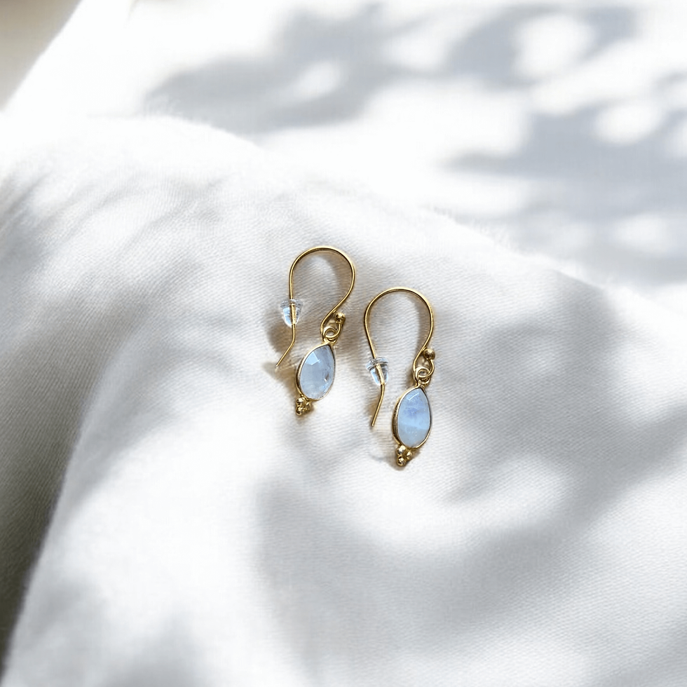 Boucles d’oreilles gouttes en pierres naturelles pierre de lune sur tissus blanc
