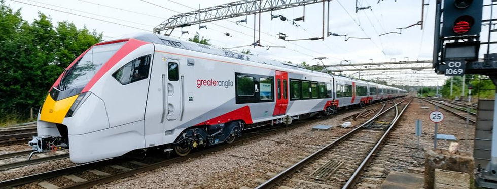 Modern white and red Greater Anglia train on tracks under power lines.